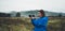 Photographer tourist girl in blue raincoat hold in female hands photo camera take photography froggy mountain, traveler shooting