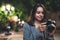 Photographer tourist girl using retro camera on background bokeh light in evening city, Blogger photoshoot hobby