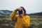 Photographer tourist take photo on camera lens on background autumn foggy mountain, traveler hipster shooting video nature mist