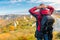 Photographer traveler with a backpack admiring beautiful mountains in autumn