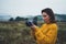 Photographer traveler take photo on video camera on background autumn froggy mountain, tourist shooting nature mist landscape