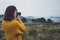 Photographer traveler take photo on video camera closeup on background autumn froggy mountain, tourist shooting nature mist land