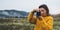 Photographer traveler take photo on video camera closeup on background autumn froggy mountain, tourist shooting nature mist land
