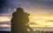 Photographer with two cameras taking a shot of sunset from roof