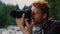 Photographer using photo camera. Man taking photos during hike in mountains