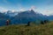 Photographers stay on lake and takes photos. Dreamy mountains, orange sunrise in a beautiful valley. Colorful summer