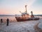 Photographers take photos of a ship washed up on the coast of the Arctic ocean by a storm