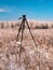 A photographers tripod against the backdrop of a winter landscape
