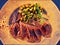 Photographic art picture of typical Russian snack - slices of salty herring fish with green sweet beans on white plate