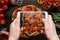 Photographing food. Hands taking picture of delicious pizza with smartphone