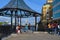 Photographing tourists at a pavilion next to the museum ship `Belfast` with a view of the Tower Bridge in London on a sunny day