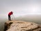 Photographr looking into viewfinder of dslr digital camera stand on tripod. Artist photographing mountain and cloudy landscape