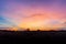 Photographs of the sky after the sunset, with colorful and shaded grasslands in the community crossing the horizon