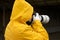 Photography in bad weather. A man in a yellow raincoat takes photos with a camera with a telephoto lens. Copy space