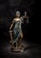 Photography of bronze themis sculpture, femida or justice goddess on dark background