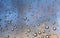 a photography of a bunch of water droplets on a window, bubbles of water are on a window glass as the sun sets