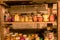 Photography with canned jars in the basement of the house, jars of different shapes on wooden shelves, various canned food, autumn