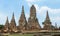 a photography of a group of tall buildings in a field, stupa krap temple in a green field with a blue sky