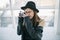 Photography hobby. Stylish ypung photographer girl in black hat. Soft backlight