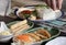 a photography of a person placing a piece of food on a plate, plate of food with rice, vegetables, and meat on a table