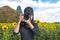 Photography and Traveler asian women covering her face with the camera in the sunflower field