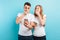 Photos of shocked people, man and woman, holding smartphones in their hands, on a blue background