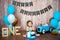 Photoshoot crush smashcake for a little boy gentleman. Decorated photozone with a wooden retro car and helium balloons. Happy