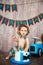 Photoshoot crush smashcake for a little boy gentleman. Decorated photozone with a wooden retro car and helium balloons. Happy