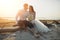 Photoshoot lovers in a wedding dress on the beach near the sea