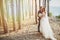 Photoshoot lovers in a wedding dress on the beach near the sea