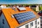 Photovoltaic solar panels in white modern house roof in a European city. Energy tax credits and green financing concept.