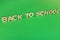 Phrase Back to school made of wooden letters on green background