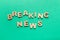 Phrase Breaking news made of wooden letters on green background