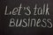 The phrase on a chalk board `Lets talk business`