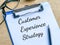 Phrase CUSTOMER EXPERIENCE STRATEGY written on paper clipboard