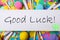 Phrase GOOD LUCK written on note and party decor, top view