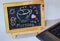 Phrase Good Morning coffee written on a chalkboard on it and smartphone, laptop