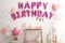 Phrase HAPPY BIRTHDAY made of balloon letters on white wall