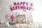 Phrase HAPPY BIRTHDAY made of pink balloon letters in room