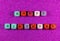 Phrase Happy Birthday written with colorful cubic beads on a purple background