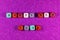 Phrase Happy New Year written with colorful cubic beads on a purple background