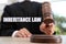 Phrase Inheritance law and judge with gavel at wooden table indoors, closeup