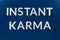 The phrase instant karma laid with silver metal letters on classic blue painted board background