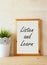 The phrase listen and learn written over white drawing board against rustic textured wall