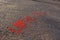Phrase LOVE IS and three dots written on the asphalt, ground. Red color of chalk.