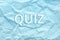 Phrase QUIZ on crumpled light blue paper