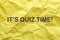 Phrase IT`S QUIZ TIME on crumpled yellow paper