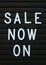The phrase Sale Now On in white text on a letter board