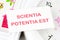 the phrase Scientia Potentia Est (Knowledge is power) written in Latin on a white card