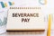 The phrase Severance Pay is written in a notepad that lies on a table with financial charts and diagrams. Business concept